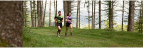 Corredores de trail running con equipación Trangoworld en un sendero por el bosque