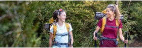 Montañeras con mochila de travesía caminando por sendero