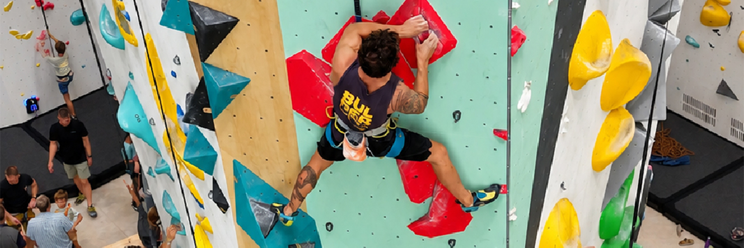 Persona escalando en Bulderland Las Fuentes, sala de escalada en cuerda en Zaragoza,  durante la inauguración