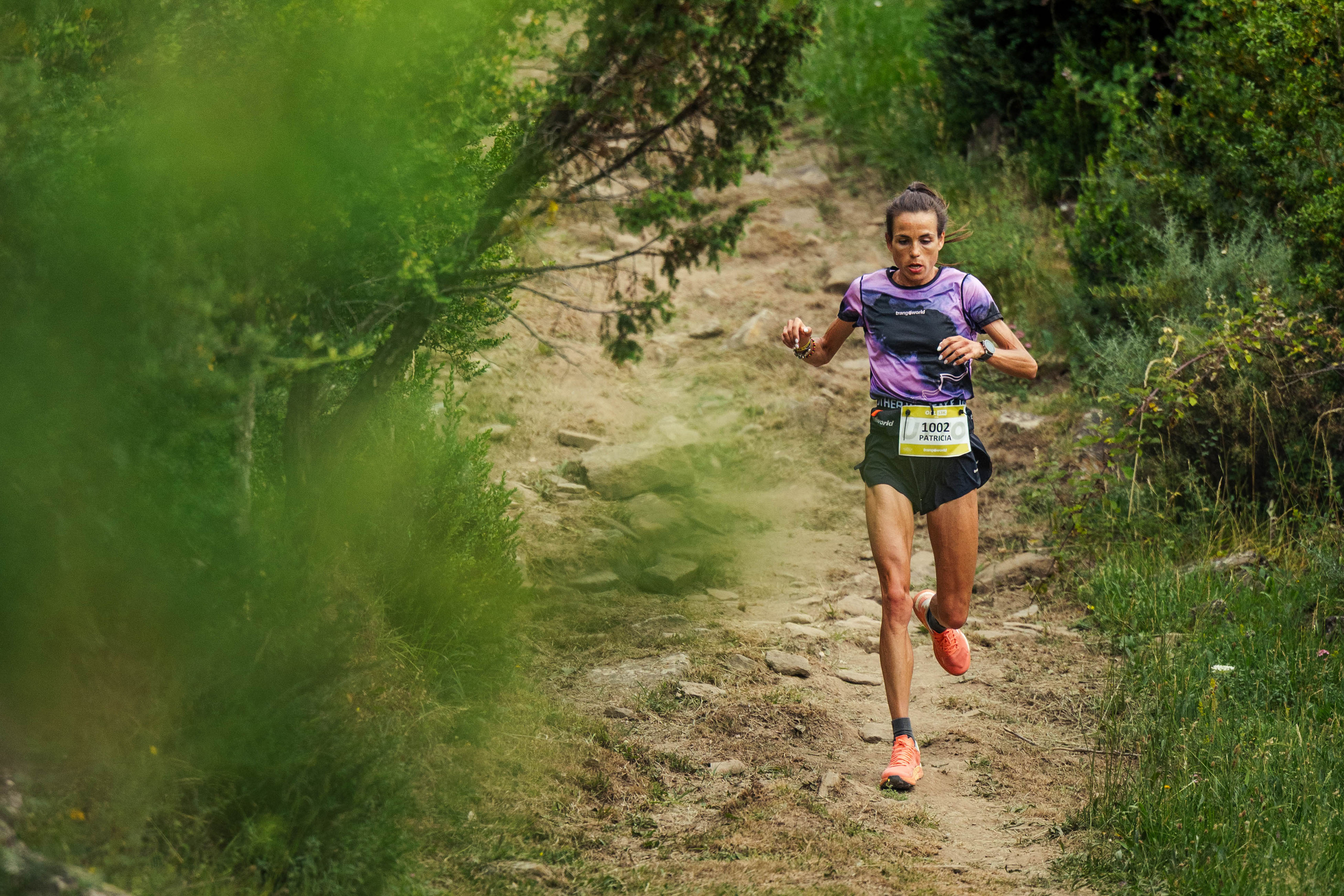 Patricia Villanueva bajando un sendero entre vegetación Patricia Villanueva bajando corriendo por un sendero rocoso y vegetación