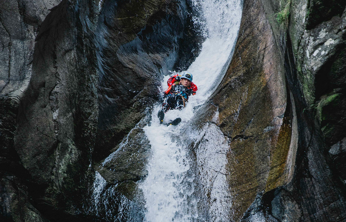 Barranquista deslizándose por un tobogán en el Barranco de Núria Barranquista descendiendo una cascada encajonada en el barranco de Núria, Pirineo catalán