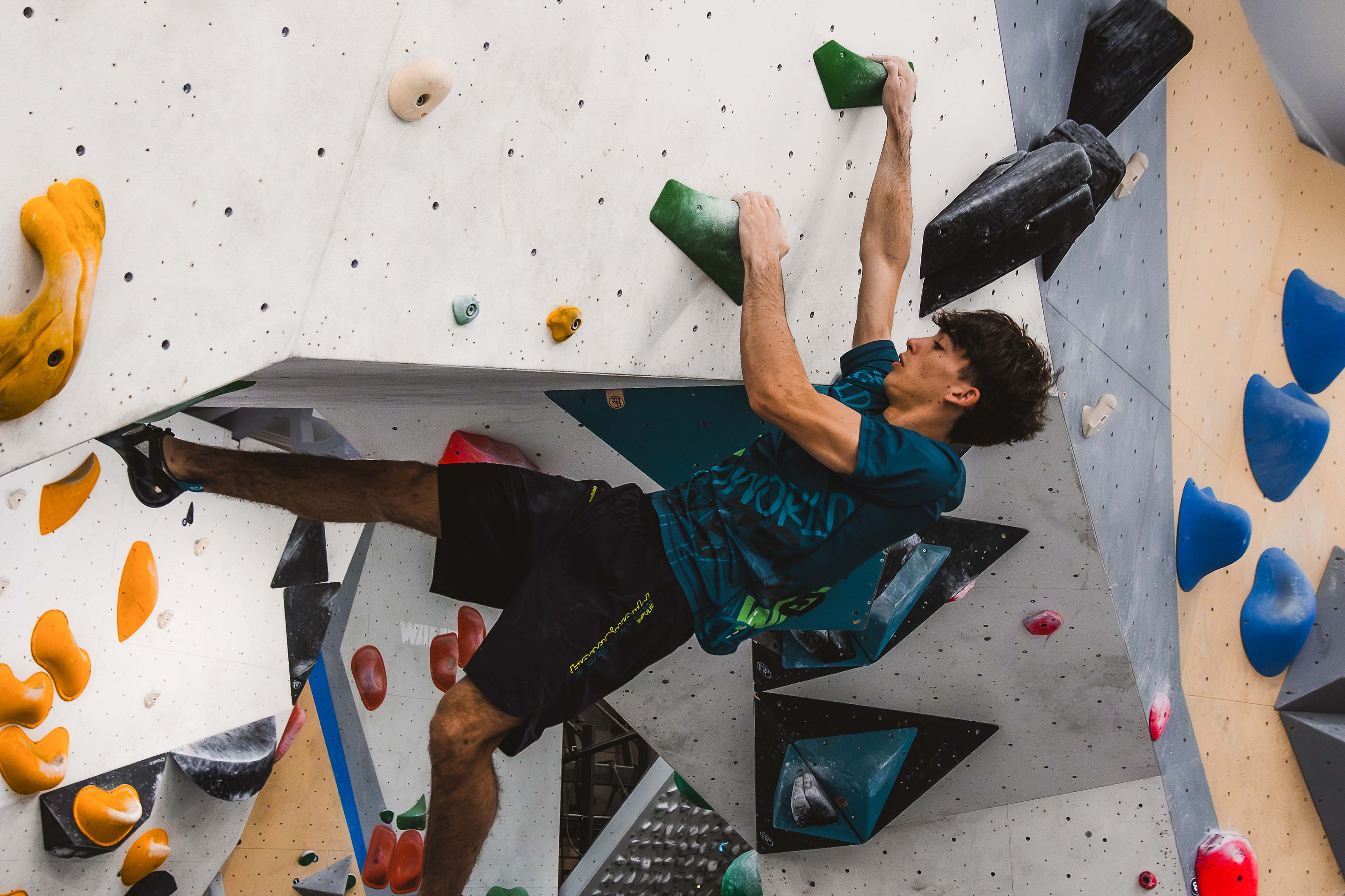 Guillermo Peinado · Bouldering indoor · Trangoworld Guillermo Peinado escalando en sala de boulder indoor con camiseta técnica Trangoworld