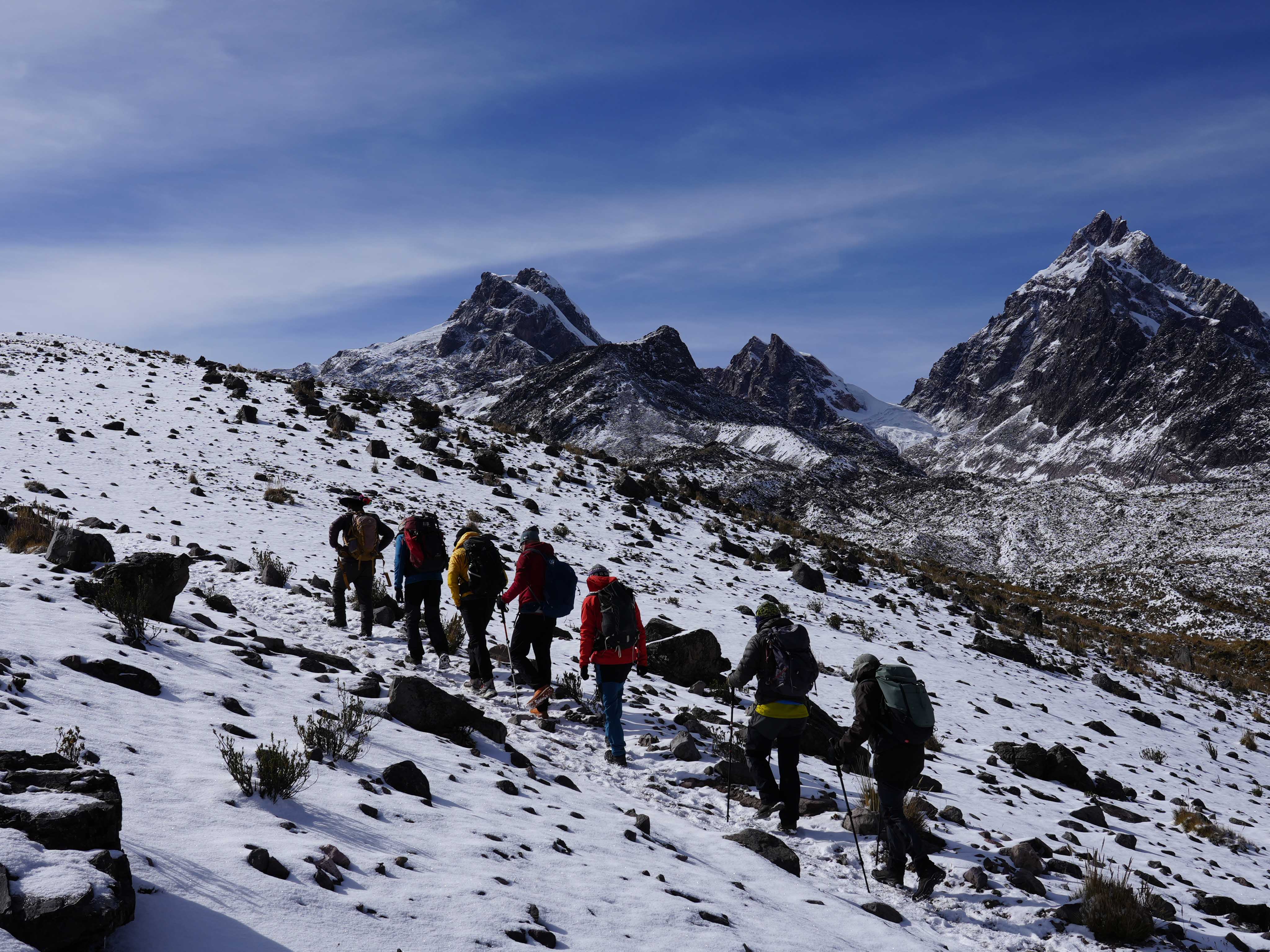 Juan Diego Amador guiando un trekking de alta montaña Juan Diego Amador guiando un grupo de montañeros en un trekking por terreno nevado y rocoso de alta montaña