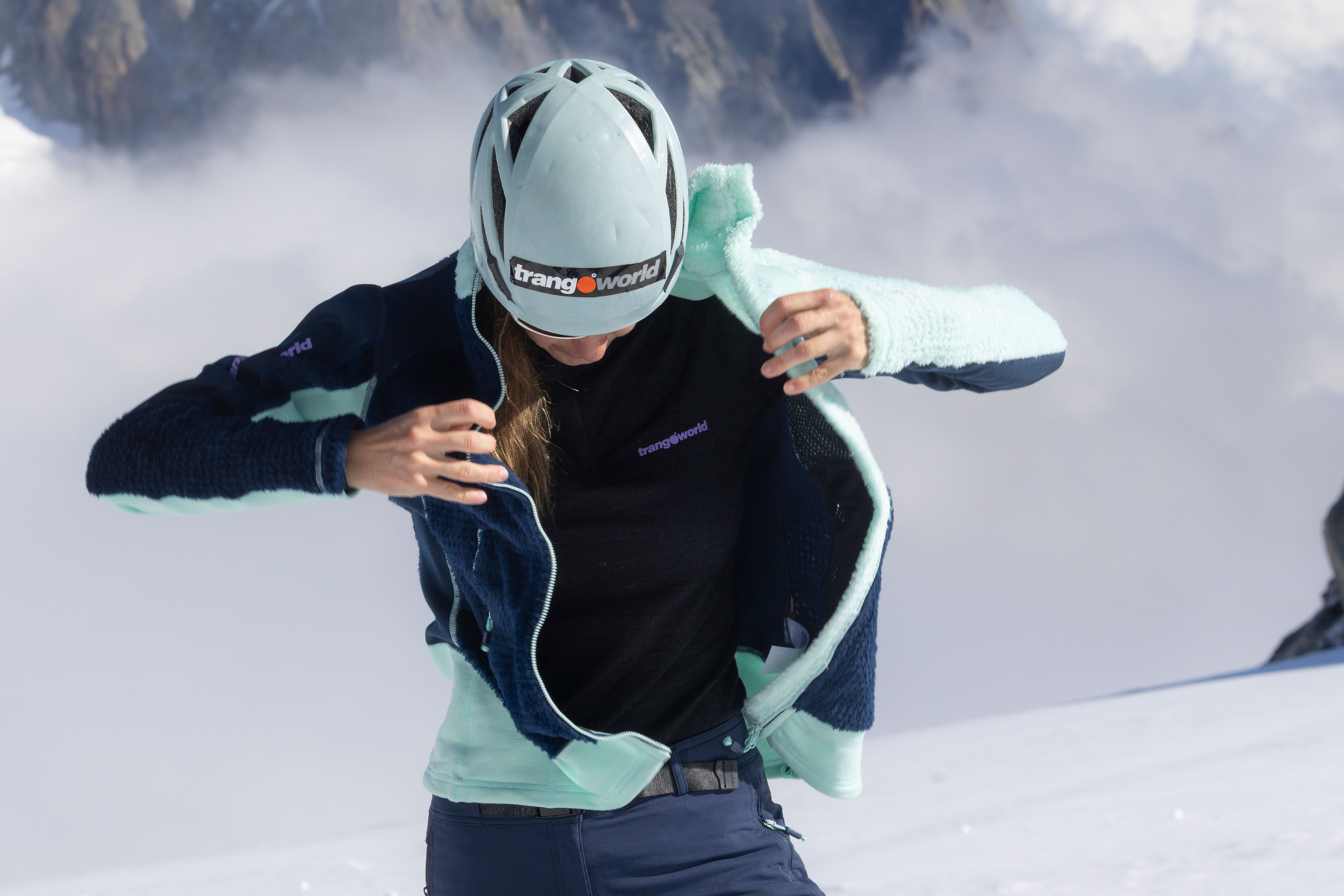 Sistema de capas en montaña. Primera y segunda capa. Trangoworld Mujer mostrando el sistema de capas de montaña en invierno con camiseta térmica y forro polar Trangoworld