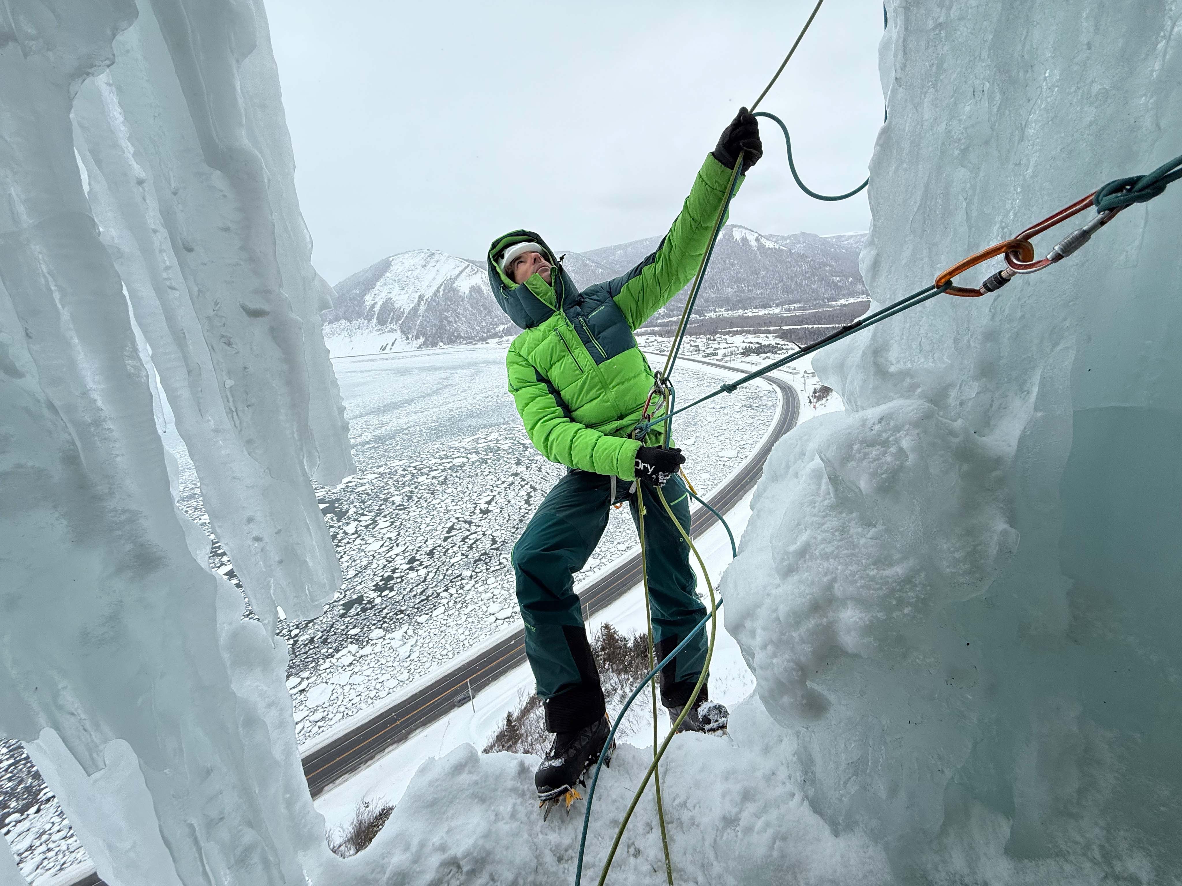 Santi Padrós asegurando entre bloques congelados Santi Padrós escalando entre pilares de hielo con paisaje invernal